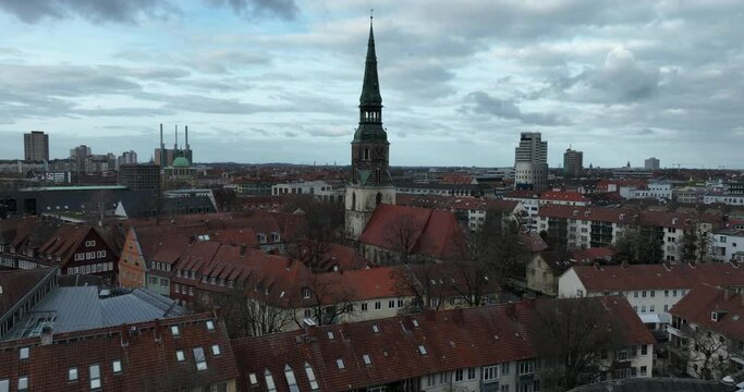 Schloss- und Stadtkirche St. Crucis in Hanover, Germany. Urban city view. Birds eye aerial drone footage. Cloudy day.