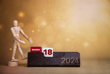 March's vibrant presentation: Wooden figure points to the eighteenth day on a bright calendar with...