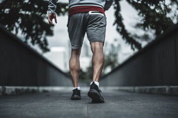 A man get ready to start running in the city center park before cardio workout.  Health and Lifestyle in big city life concept. - obrazy, fototapety, plakaty