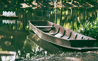 Thai wooden rowboat along riverside on natural light background.