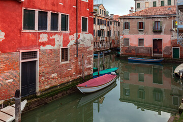 Fototapeta na wymiar Small boat on a small canal street in Venice of beautiful colorful houses, Italy