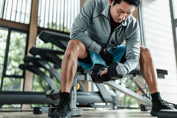 A man doing exercises biceps with dumbbell  in gym. Fitness, workout and traning concept.