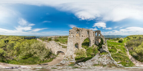 Fototapeta premium Wide panoramic view on old fortress in mountain landscape with lush green hills under clear blue sky, perfect for outdoor enthusiasts. Seamless 360 degree spherical equirectangular panorama.