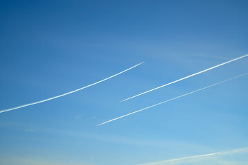Traces of planes flying towards each other in the sky.