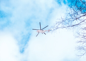 White helicopter in the blue sky