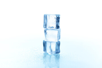 Three beautiful large pieces of ice with drops of water on a light background.