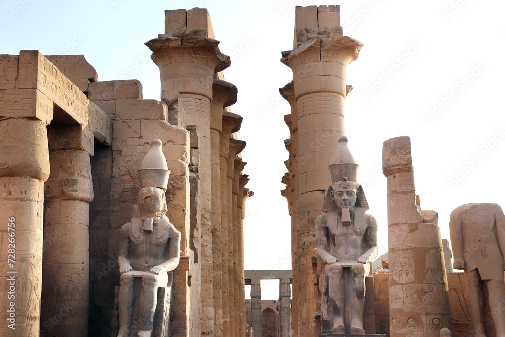 Sticker Ancient Statue of Ramesses II, Luxor Temple, in the light of sunset. Great columns and sculptures at entrance of famous landmark - Egyptian temple as Luxor (Thebes), Egypt, North Africa