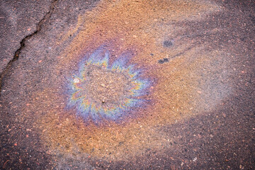 A puddle of spilled gasoline or oil product on the road.