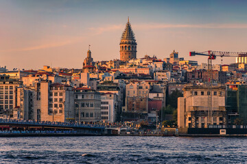 Fototapeta na wymiar Sunrise cityscape of the Karakoy area across Bosphorus Strait by Galata Bridge with the Galata Tower at the golden hour of sunset in Istanbul, Turkey