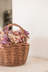 Fototapeta na wymiar Colorful dried floral arrangement in woven basket on white background