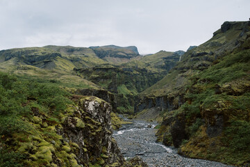 Remote hiking trail in Iceland surrounded by green mossy mountain