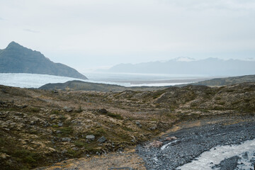 Iceland countryside road with mountains and mossy icy ground