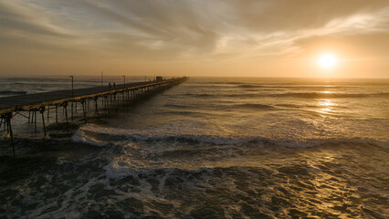 Obraz premium Pier in the ocean on a colorful sunset. Puerto Eten.