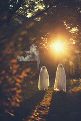 Whimsical Ghost Costumes in Autumn Twilight for Halloween Themes or Fantasy Concepts