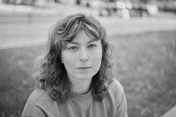 Portrait of happy mature woman looking at camera. Successful proud woman in city street at sunset. Satisfied Caucasian woman in formal clothing smiling outdoors. High quality photo