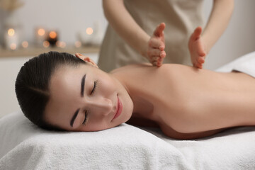 Fototapeta na wymiar Woman receiving back massage on couch in spa salon