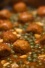  Tasty meatballs cooked with tomato and peas sauce