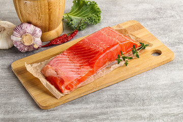 Raw salmon fillet over board