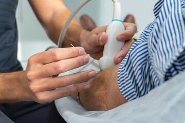 close-up of a hand performing dry needling with needle and ultrasound