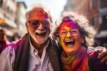 Senior couple laughing with Holi colors on city street