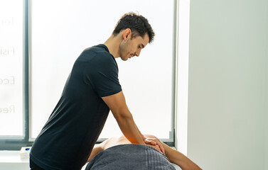 physiotherapist giving a massage on the back of a lying client