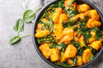 Aloo Saag South Asian curry made with potatoes and spinach with spices closeup on the bowl on the...