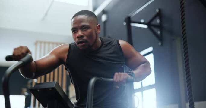 Fitness, spin class and black man in gym for training, intense workout and exercise for healthy body. Sports, cardio machine and person on cycling equipment for performance, muscles and wellness