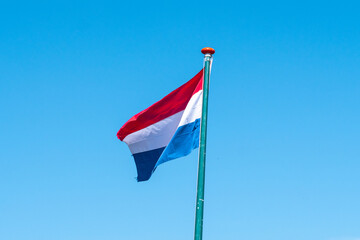 Welcome to Holland above a river and the windmills of Zaanse Schans, the Netherlands with its traditional houses, windmills, warehouses and workshops.