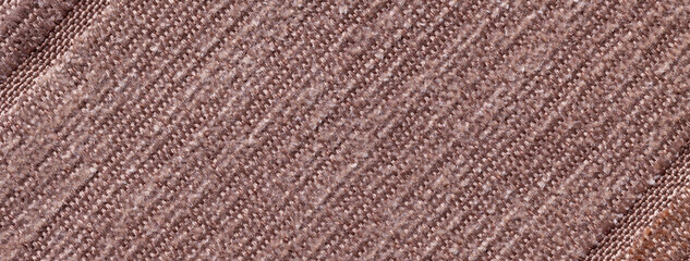Dark brown background of knitted textile material with diagonal pattern. Fabric backdrop with umber striped texture