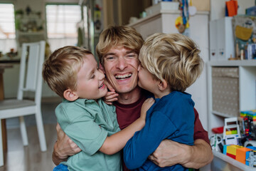 Two sons kissing father's cheeks. Concept of Father's Day, and fatherly love. Real family, real...