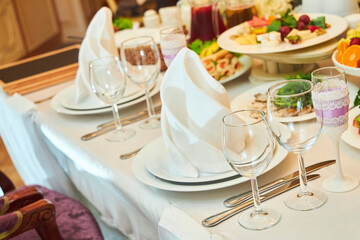 The setting of the festive table. Food and dishes. Festive glasses for drinks.