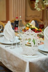 The setting of the festive table. Food and dishes. The table number.