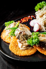 potato pancakes with meat, mushrooms and creamy sauce