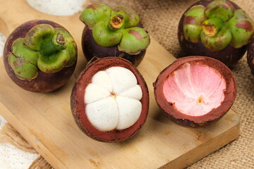 Fresh Mangosteen in bamboo basket on white background. Mangosteen has been known as The Queen of...