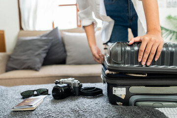 Young woman sit in floor and preparation suitcase for travelling at weekend trip