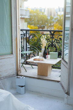 Vase with wine bottle and food on table in balcony