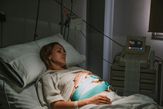 Pregnant woman resting on hospital bed in delivery room
