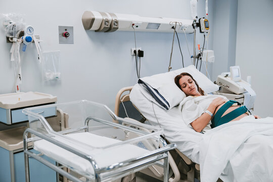 Pregnant woman resting on bed in delivery room
