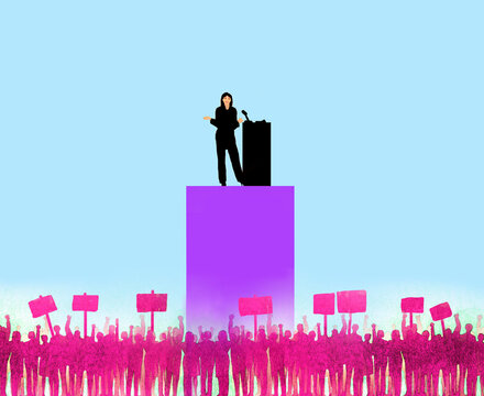 Woman with lectern addressing protesters against blue background