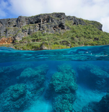Coastline with cliff and rocky reef eroded by the swell underwater, split view half over and under water surface, natural scene, south Pacific ocean, Rurutu, French Polynesia