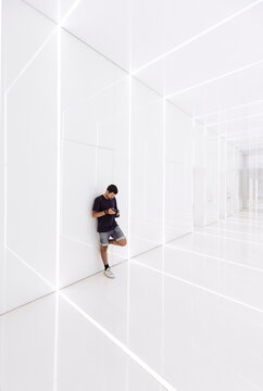 Young man using smart phone in modern corridor