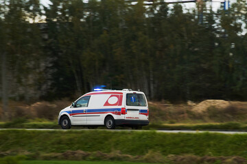 Emergency Response in Action as an Ambulance Travels Quickly on a Wintry Road Amidst Nature