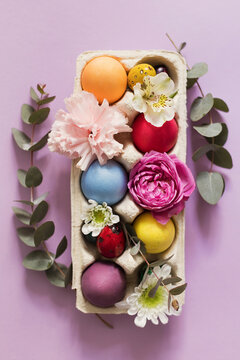 Colorful Easter eggs decorated with flowers on pink background