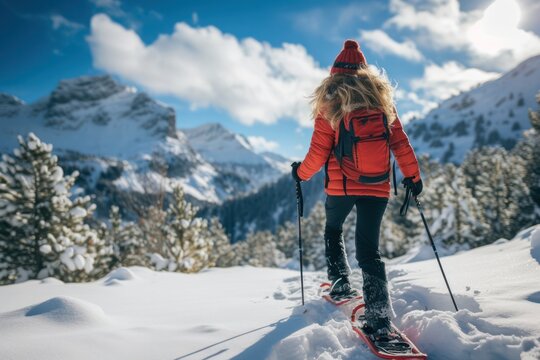 Young woman snowshoeing in the mountain.