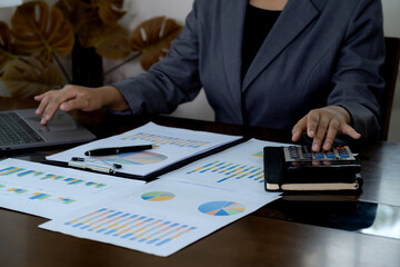 Businesswomen bookkeeper hand use calculator analysis the graph for Setting challenging business...