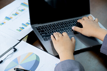 Businesswomen bookkeeper hand use laptop analysis the graph for Setting challenging business goals...