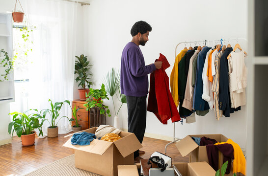 Man decluttering clothes for recycling at home