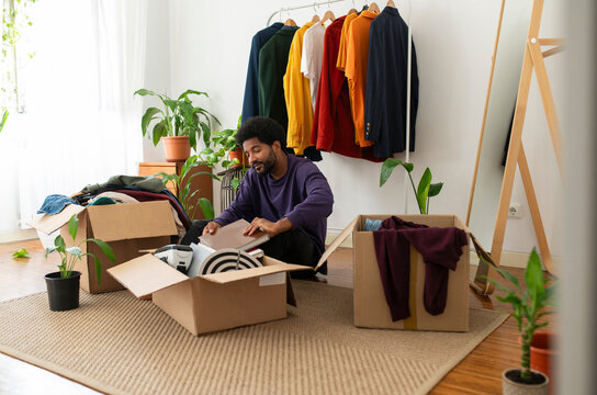 Man organizing clothes and objects in cardboard boxes