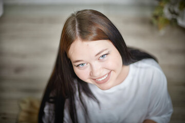Obraz premium People and lifestyle concept. Body positivity. Indoor portrait of positive young Caucasian girl with chubby cheeks enjoying at home, smiling