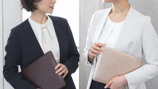 立ちながら話をするジャケットを着た女性2人